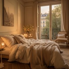 a large bed sitting in a bedroom next to a window with candles on top of it