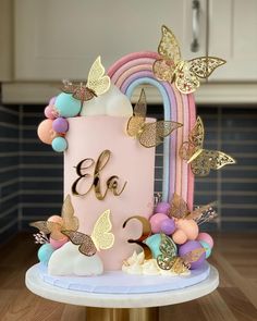 there is a pink cake with gold butterflies on it and the number 3 in the middle