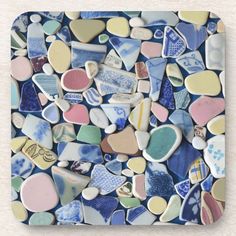 a square coaster made out of various colored glass hearts on white marble paper with blue and pink accents