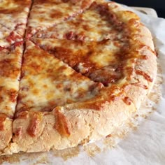 a cheese pizza sitting on top of a white paper towel next to a slice missing from it