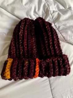 a crocheted hat laying on top of a bed