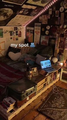 a bed with a laptop on top of it in a room that has pictures all over the walls