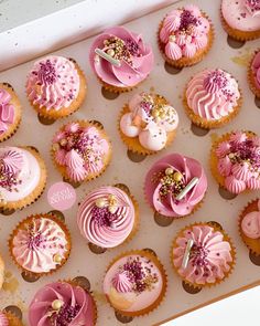 a box filled with pink cupcakes covered in frosting