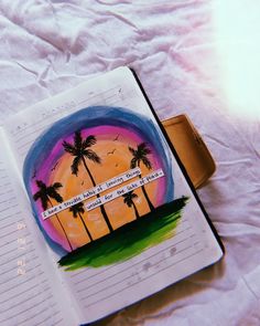 an open notebook with palm trees painted on it