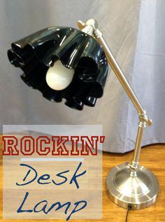 a desk lamp sitting on top of a wooden floor next to a sign that reads rockin'desk lamp