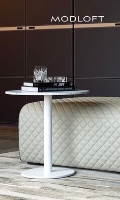 a white table sitting on top of a wooden floor next to a couch and coffee table