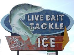 a sign that says live bait tackle with a large fish on it's side