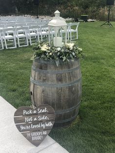 a wooden barrel with flowers on it and a sign that says pick a seat not a side