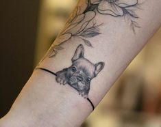 a tattoo on the arm of a person with a dog's head and flowers