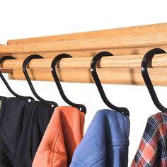 three coats hanging on a coat rack with hooks