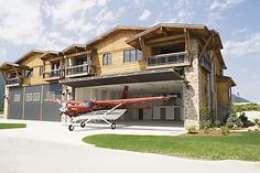 a red and white plane parked in front of a house