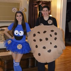 two people in costumes standing next to each other with cookies on their faces and legs