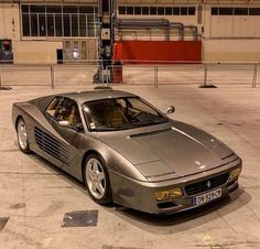 a silver sports car parked in an empty parking lot