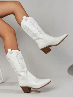 a woman in white cowboy boots sitting on a stool