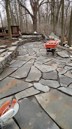 an outdoor patio with stone pavers, benches and fire pit in the middle of it