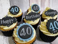 cupcakes decorated with black and white frosting are sitting on a table