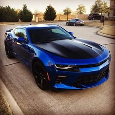 a blue chevrolet camaro is parked on the street