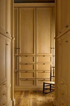 an empty room with wooden furniture and hard wood flooring on one side, looking into the closet