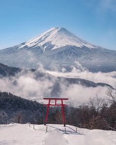 a snow covered mountain is in the distance with a red sign on it's side