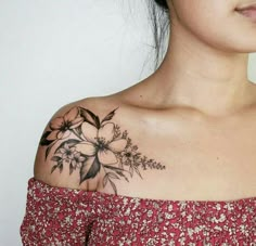 a woman with a flower tattoo on her upper arm and shoulder is looking at the camera