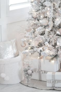 a white christmas tree with presents under it