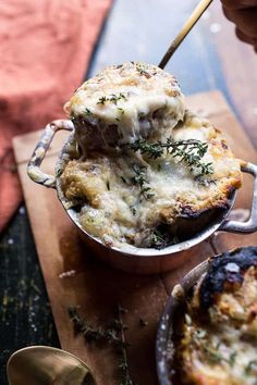 a close up of food in a pan on a wooden table with utensils