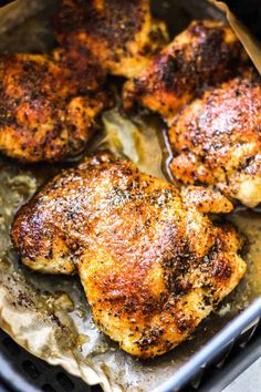 three pieces of chicken sitting on top of a pan