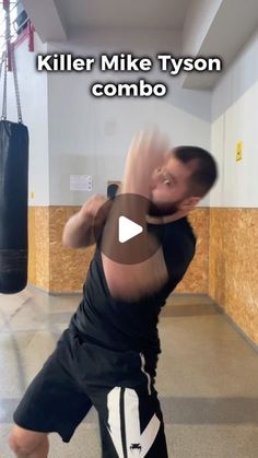 a man in black shirt and shorts standing on one leg with boxing gloves hanging from the ceiling