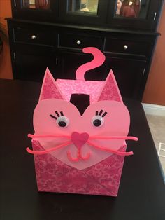 a pink paper bag with a cat's face on it sitting on a table