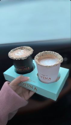 two cups of coffee sitting on top of a blue box