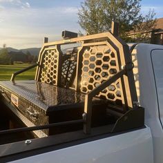 the back end of a white truck with metal grills on it's flatbed