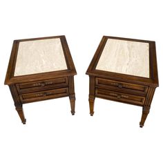 a pair of wooden tables with marble top on each side and one drawer at the end