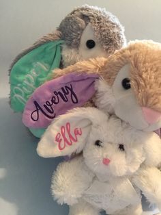 three stuffed animals sitting next to each other on a white surface with the name avery written on them