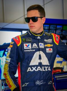 a man in a racing suit and sunglasses