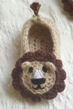 a crocheted lion slipper is laying on a blanket