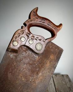 an old pair of scissors sitting on top of a piece of wood with holes in it