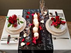 a table set for valentine's day with roses and candles