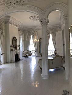 an ornate living room with white marble flooring and high ceilinged ceilings is pictured in this image