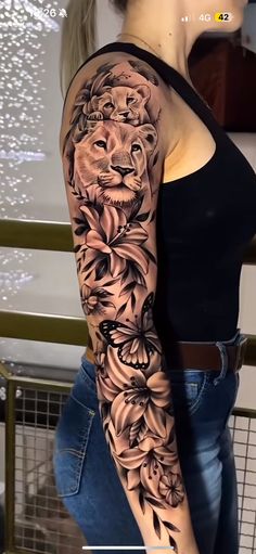 a woman's arm with flowers and a lion on it