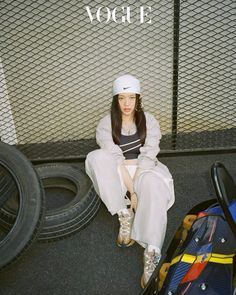 a woman sitting on the ground next to some luggage