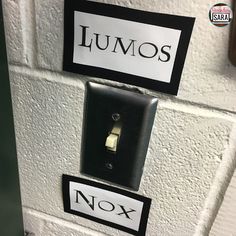 two black and white light switch plates on a brick wall with spanish words written on them