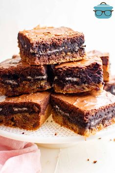 a stack of brownies sitting on top of a white plate