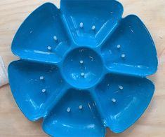 a blue flower shaped dish sitting on top of a wooden table