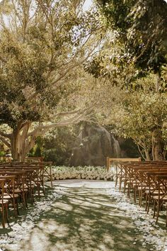 an outdoor ceremony setup with wooden chairs and tables