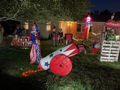 a group of people dressed up as clowns in front of a house at night