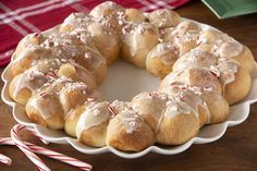 a white plate topped with donuts covered in icing and peppermint sticks