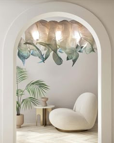 a white chair sitting under a light fixture next to a potted plant