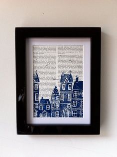 an old book page is framed in a black frame on the wall above a shelf