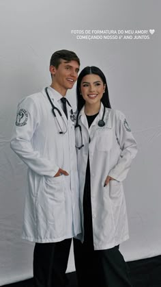 two doctors standing next to each other in front of a white backdrop