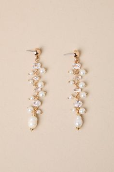 two pairs of pearl and crystal earrings on top of a white surface with gold accents